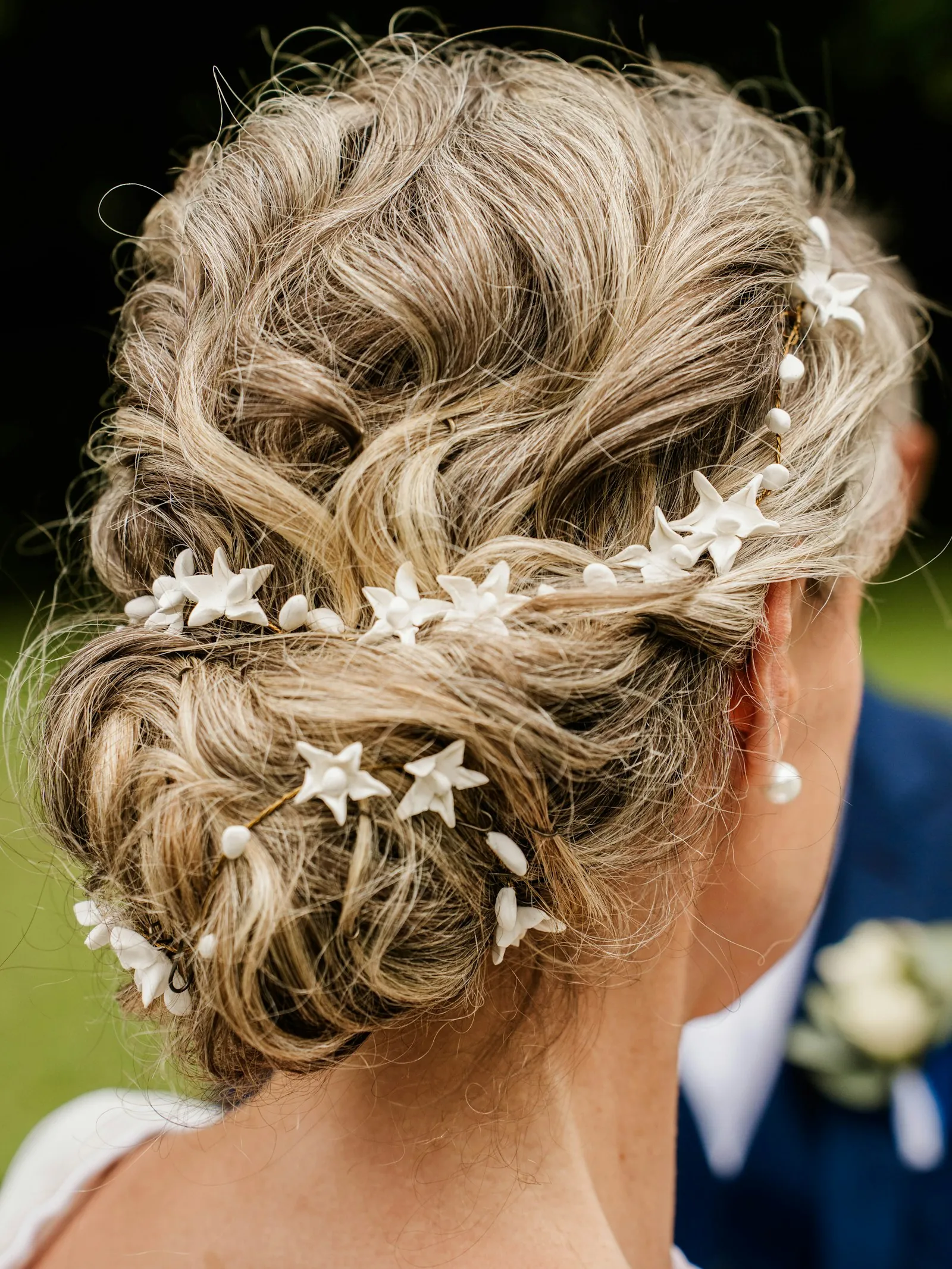 Soft textured updo with flower pins, seen from behind