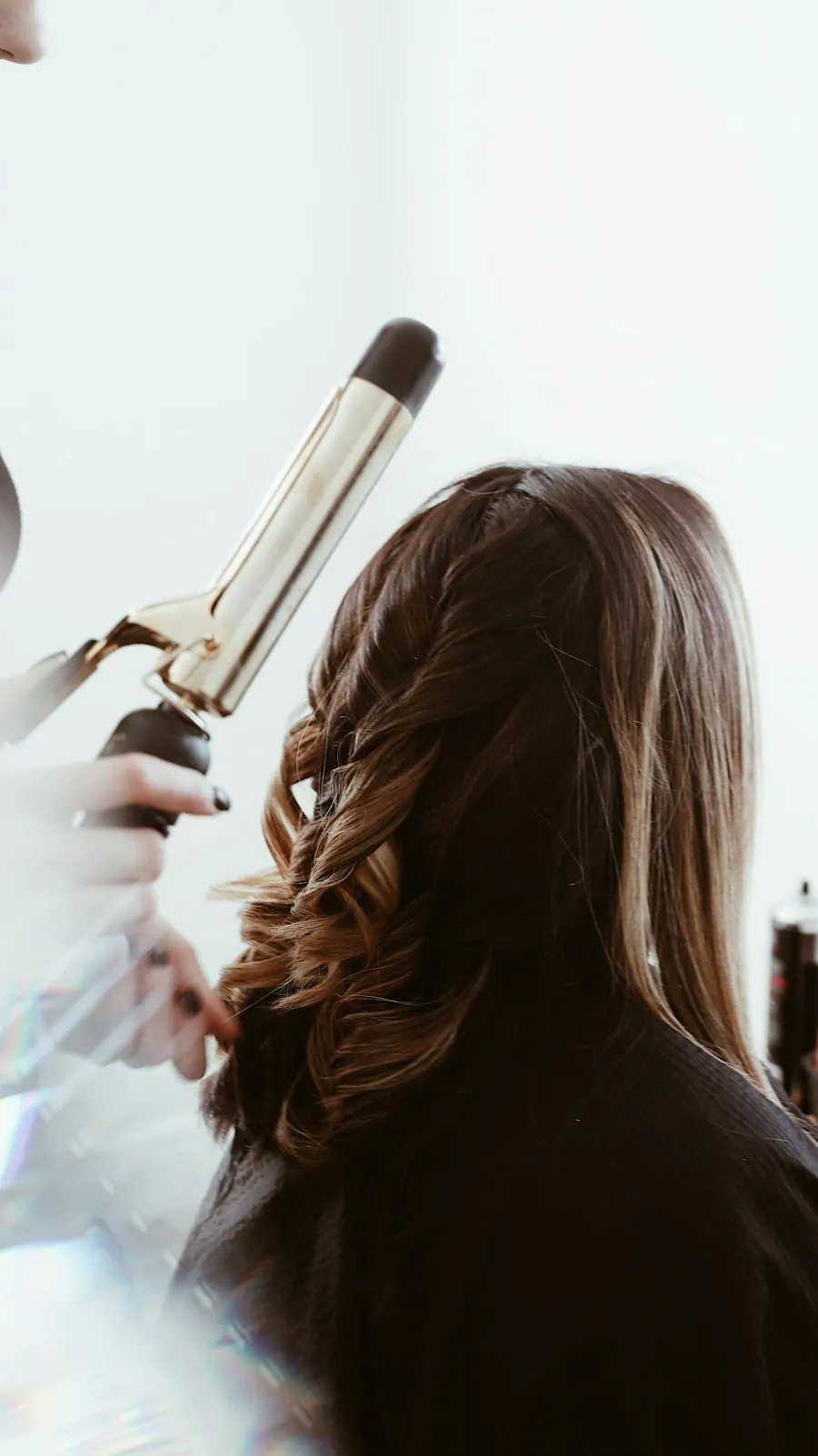 Stylist curling long brown hair