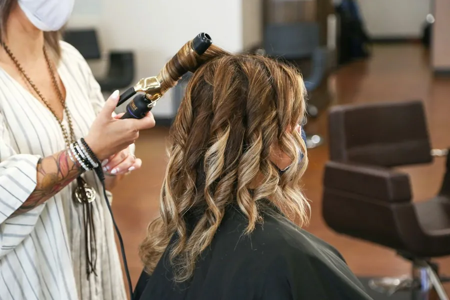 Stylist curling a client's balayage